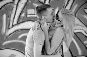 Молодая пара, парень и девушка, целуются на фоне графитти